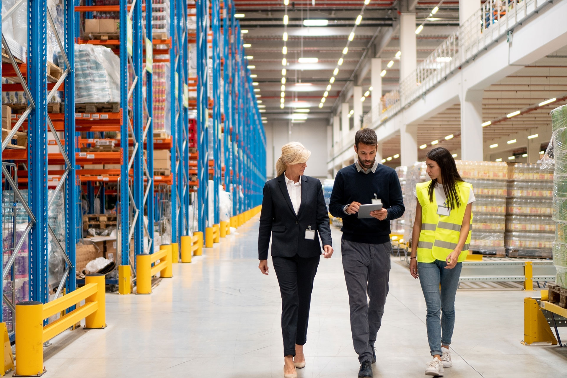 Procurement executives walking through warehouse operations enabled by the Next Gen Procurement framework with Jabil